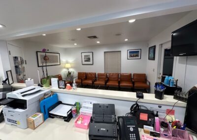 Interior of a dentist's office showcasing a desk with a printer and computer, emphasizing a clinical and efficient environment.