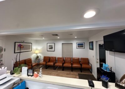 Interior of a dentist's office showcasing a desk with a printer and computer, emphasizing a clinical and efficient environment.